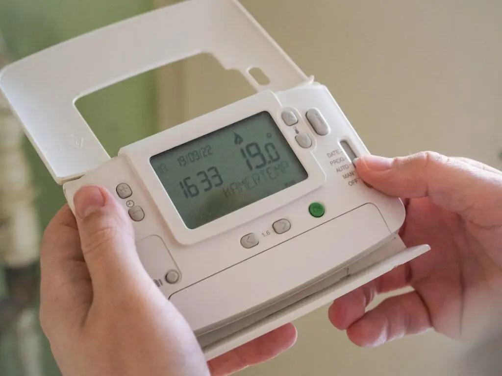 homeowner checking a blank thermostat during an unexpected HVAC breakdown