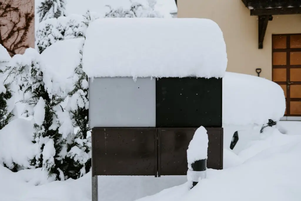snow-covered residential heat pump unit in Pacific Northwest winter