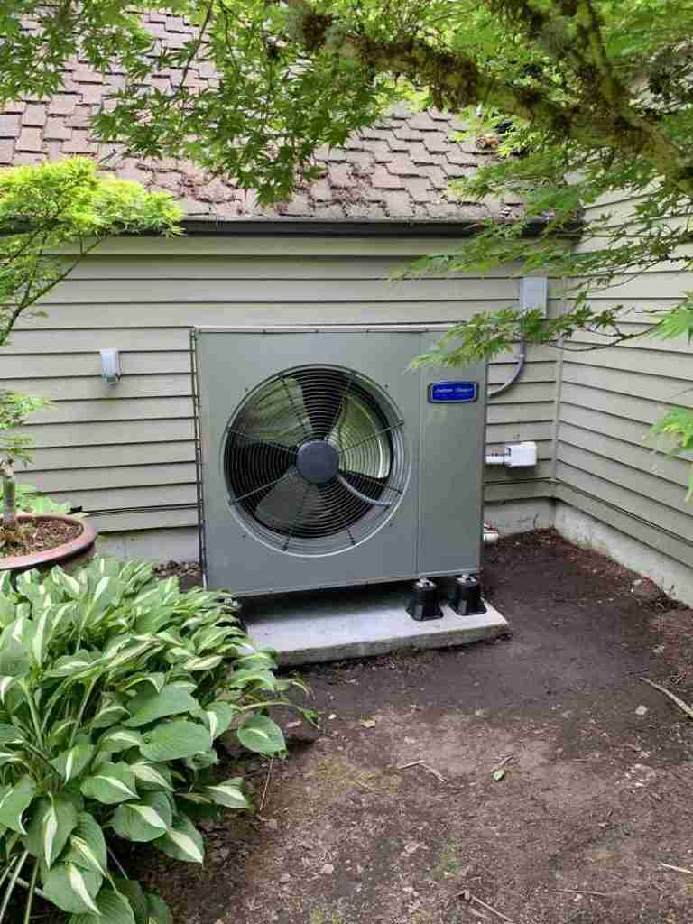 homeowner inspecting old residential HVAC unit outside a home in Puyallup Washington