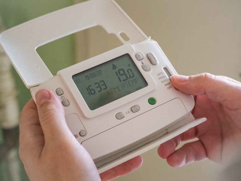 homeowner checking a blank thermostat during an unexpected HVAC breakdown